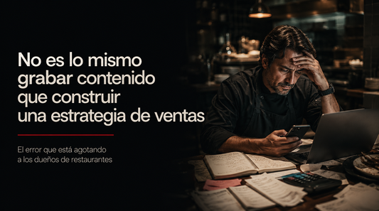 Dueño de restaurante agotado grabando contenido con celular, computadora y papeles, representando la carga de manejar marketing sin estrategia